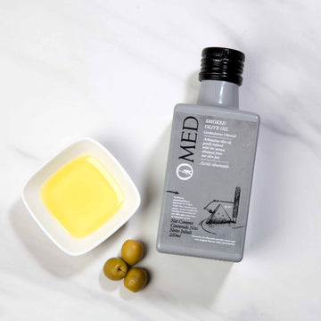 Smoked Olive Pit Arbequina EVOO on marble tabletop